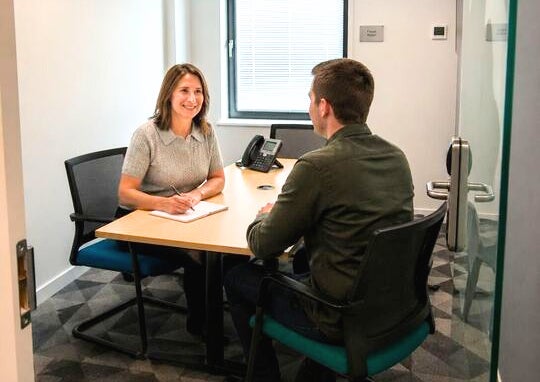 A Work Avenue business adviser meeting a client across a desk.